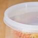 A translucent plastic deli container with a lid filled with pasta.