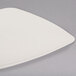 A white Fineline plastic dessert plate with a triangle shape.