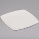 A white square Fineline plastic dessert plate with a white rim on a gray surface.