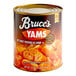 A #10 can of Bruce's Cut Sweet Potatoes with a label on a table in a grocery store aisle.