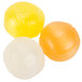 A close up of a group of round yellow and white candies.