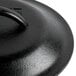 A close-up of a Lodge black cast iron lid with a black handle.