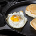 A Lodge cast iron griddle with a pancake and fried egg on it.