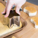 A person's hand using an Ateco stainless steel fancy shaped cutter to cut a star shaped cookie.