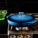 A Caribbean blue Lodge enameled cast iron casserole dish on a stove.