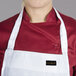 A woman wearing a white Chef Revival bib apron with a red shirt.