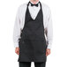 A man wearing a black Chef Revival Tuxedo Apron with a bow tie.