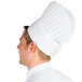 A man wearing a Chef Revival disposable non-woven chef hat.