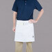 A man wearing a Chef Revival white bistro apron with 2 pockets.