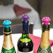 A group of wine bottles with colorful Vacu Vin stoppers.