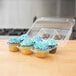 A Polar Pak plastic container holding six cupcakes with blue frosting.