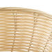 A close up of a Thunder Group round rattan bread basket.
