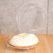 A Polar Pak clear plastic container holding a pie with white frosting on top.
