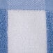 A close up of a blue and white Oxford cabana pool towel with stripes.