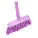 A close-up of the purple Carlisle Sparta Duo-Sweep broom with a handle.