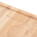 A close up of a Nemco wooden carving board.