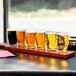 A tray of Anchor Hocking Barbary beer tasting glasses on a table in a brewery tasting room.