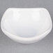 A white ceramic sauce cup with a small hole in the middle.