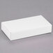 A white rectangular 1-piece candy box with a lid on a gray surface.