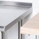 A stainless steel Advance Tabco filler table on a counter in a school kitchen.