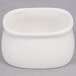 An American Metalcraft white porcelain bowl with a lid on a gray surface.