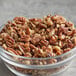 A bowl of medium raw pecan pieces on a table.