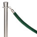 A green velvet rope with satin silver ends attached to a silver metal pole.