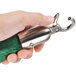 A person holding a green Aarco stanchion rope with metal ends.