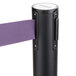 A black Aarco crowd control stanchion with purple retractable belt tape.
