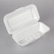A white styrofoam container with a perforated hinged lid.