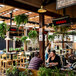 A Bromic Heating natural gas patio heater on a restaurant patio with hanging plants.