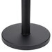 A black metal Aarco crowd control stanchion with a round base.
