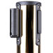 A brass Aarco crowd control stanchion with a purple retractable belt in a metal tube.