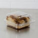 A Dart clear hinged plastic container with a piece of cake inside.