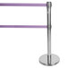 A silver Aarco crowd control stanchion with dual purple belts.