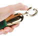 A hand holding a green rope with gold metal ends.