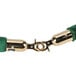 A green stanchion rope with brass ends.