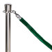 A green rope with silver ends attached to a silver stanchion pole.