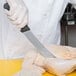 A person using a Victorinox Breaking Knife to cut up a chicken.