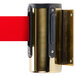A gold wall-mount stanchion with a red retractable belt.