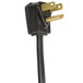 A close-up of a black electrical plug with gold colored ends.