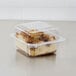 A Dart clear hinged plastic container with a cake inside.