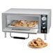 A Waring countertop pizza oven with a tray of pretzels inside.