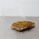 A clear plastic Dart container holding a group of cookies on a counter.