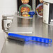 An Edlund ST-93 can opener cleaning brush on a metal counter.