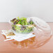 A salad in a Dart clear plastic bowl.