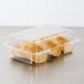 A Dart clear hinged plastic container with two rolls of bread inside.