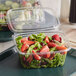A salad in a Dart ClearPac plastic container with strawberries.