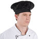 A man wearing a black Chef Revival beret with a white jacket.