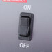 A close-up of a black and white switch on a grey surface.